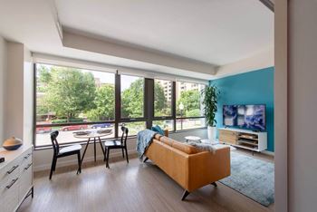 A living room with a sofa, chairs, and a television.